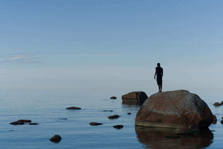 man standing on brown rock